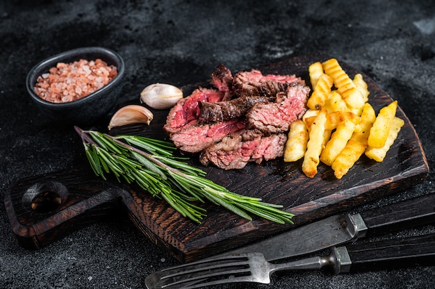 Jupe de machette rôtie steak de viande de bœuf sur planche de bois avec frites