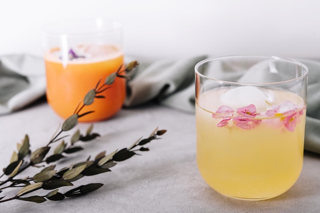 Jus d'ananas et de carotte en verre avec des cubes de glace