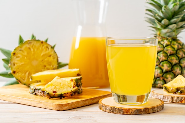 jus d'ananas frais sur la surface du bois