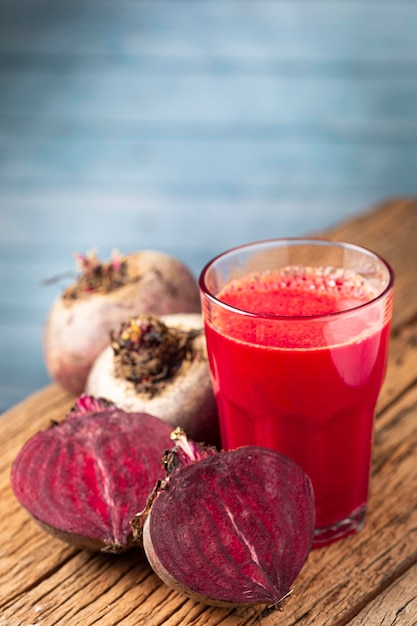 Jus de betterave rouge dans une tasse en verre sur la table en bois