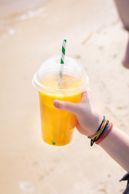 Jus de boisson glacée limonade jaune sur la plage de la côte de la mer orange fraîche boisson rafraîchissante se détendre