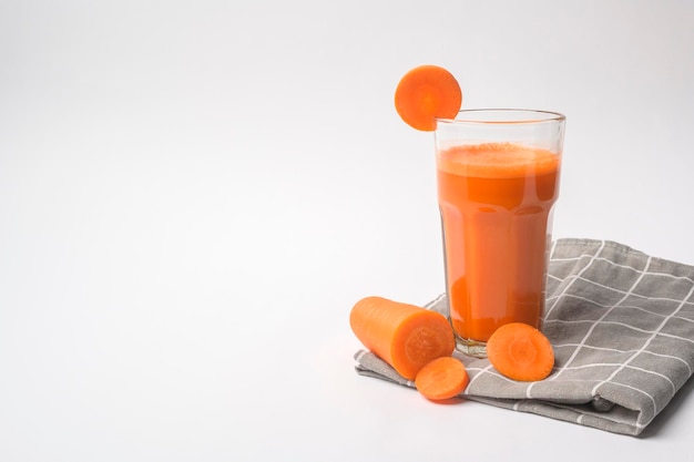 Jus de carotte sur fond blanc concept de saine alimentation