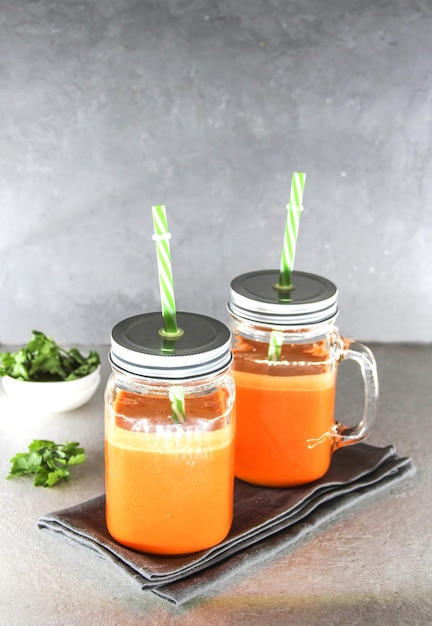 Jus de carotte frais dans des verres sur fond blanc ou table Concept d'aliments sains