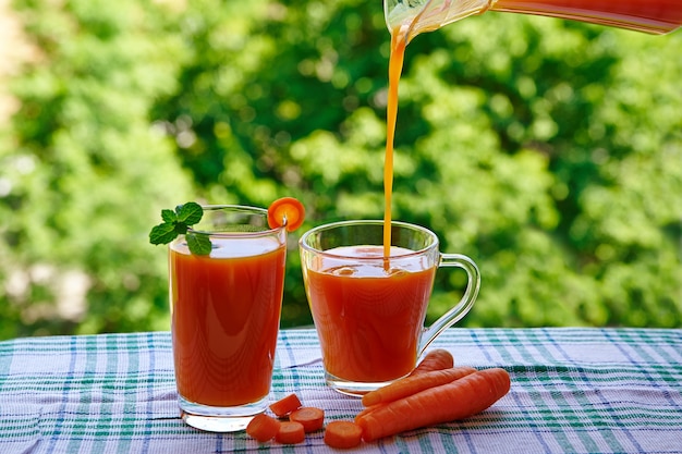 Jus de carotte frais dans des verres sur la table