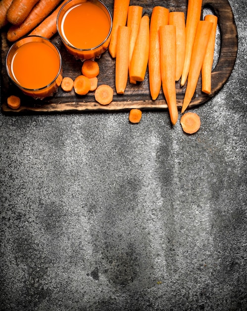 Jus de carotte frais sur table rustique.