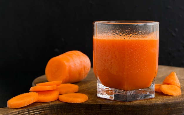 Jus de carottes fraîchement pressé sur fond noir