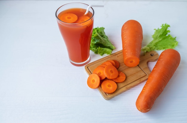 Jus de carottes fraîches en bonne santé sur la table blanche