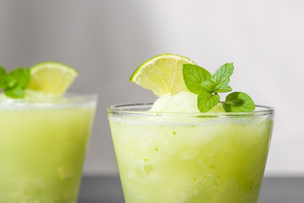 Jus de cocktail avec citron vert, menthe et glace. Accessoires de boisson de bar sur fond de tableau noir.