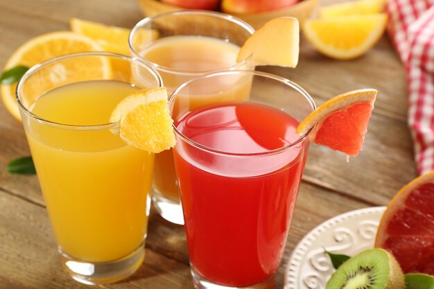 Des jus frais avec des fruits sur une table en bois