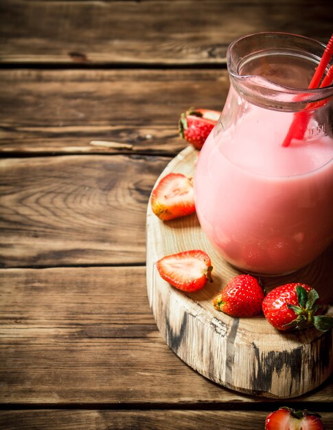 Jus de fraise dans le pichet. Sur une table en bois.