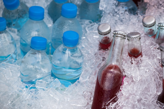 Jus de fraise fait maison et eau de boisson fraîche en bouteilles avec glace froide.