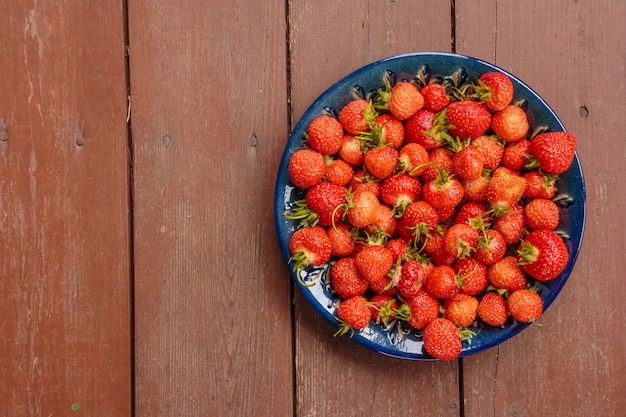 Jus de fraises dans un bol sur une table en bois.Fraises fraîches.Fruits fraîchement récoltés sur le marché fermier.Aliments sains pour le petit déjeuner et la collation.Copiez l'espace