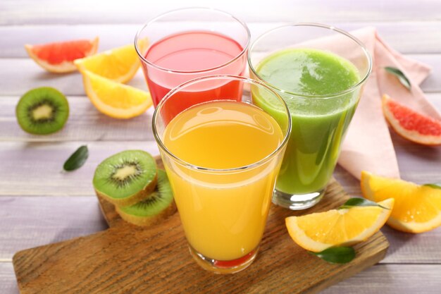 Jus de fruits frais avec des fruits sur table en bois