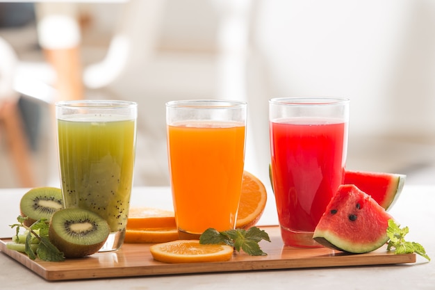 Photo jus de fruits frais smoothie trois verres rouge vert orange tropical