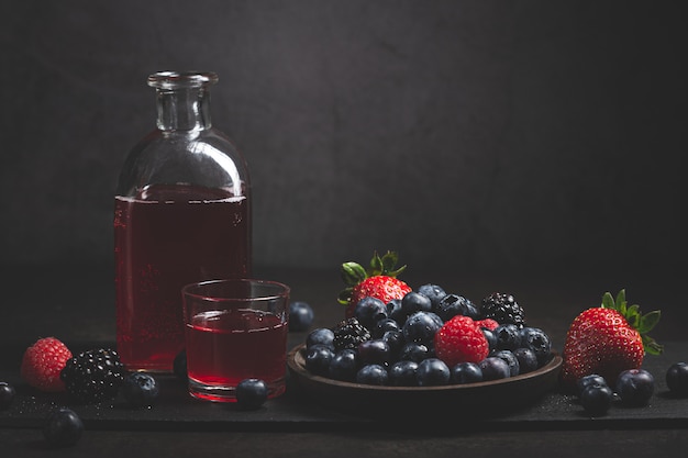 Jus de fruits rouges aux fruits rouges sur fond sombre