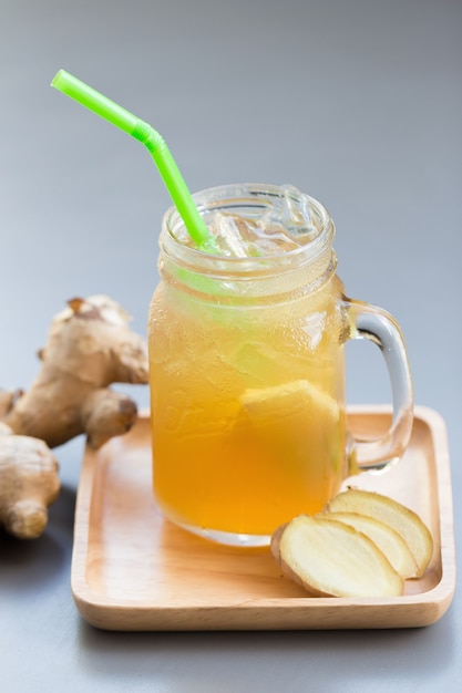 Jus de gingembre avec du sucre sur une table grise.