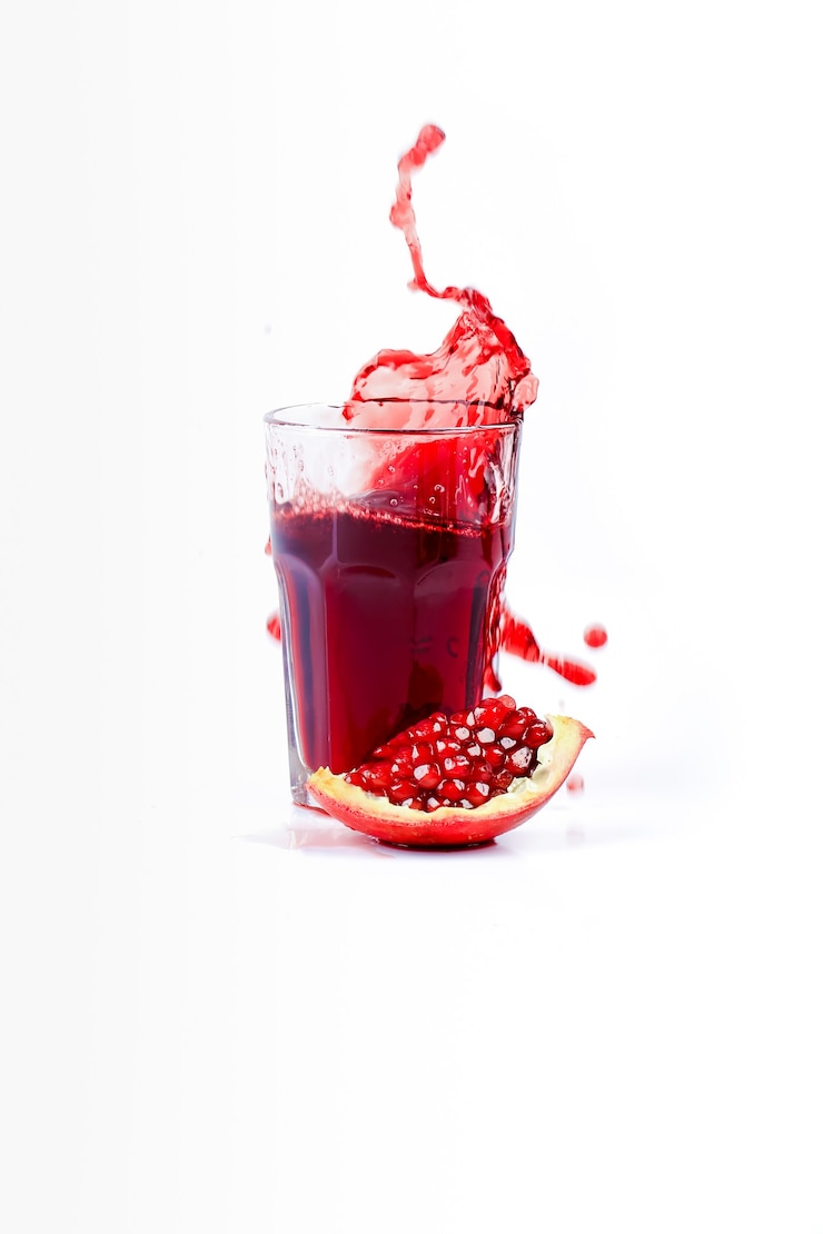 Photo jus de grenade sur fond blanc