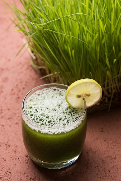 Jus d'herbe de blé ayurvédique ou médicinal avec tranche de citron en verre, mise au point sélective