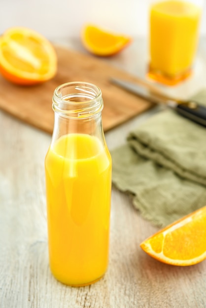 Jus de mandarine dans une bouteille et tranches d'oranges