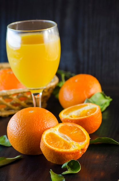 Jus de mandarine frais bio naturel dans un verre sur fond sombre