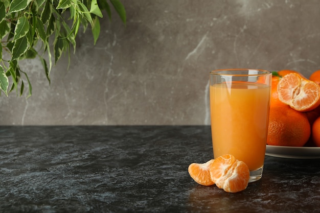 Jus de mandarine et ingrédients sur table smokey noire