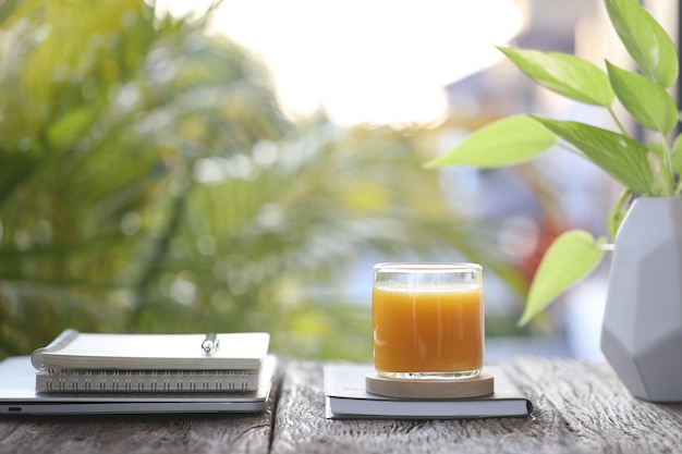 Jus de mangue et cahiers sur table en bois