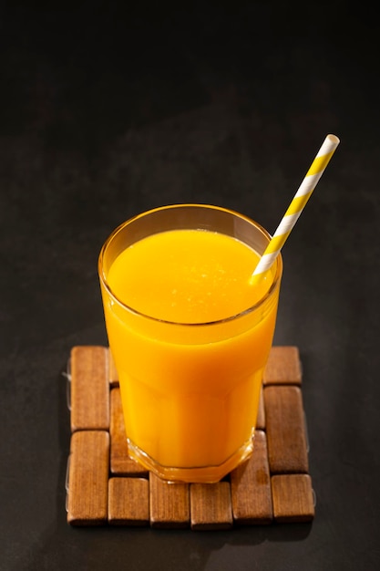 Jus de mangue dans une tasse en verre sur la table Smoothie à la mangue