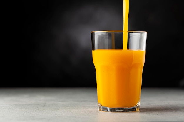 Jus de mangue dans une tasse en verre sur la table Smoothie à la mangue