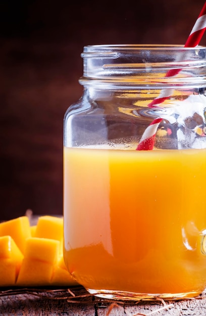 Jus de mangue avec de la paille sur la vieille mise au point sélective de fond en bois