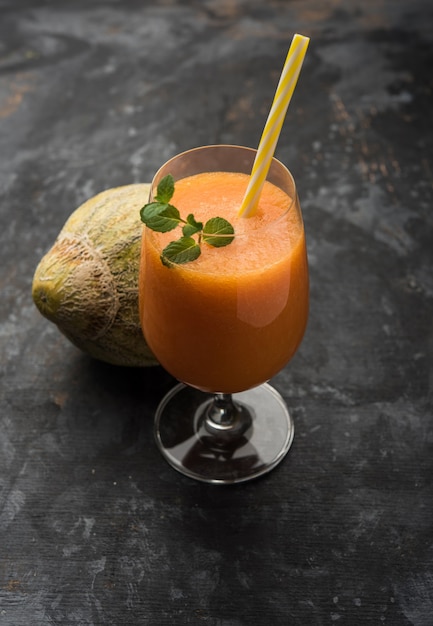 Jus de melon musqué avec tranche, également connu sous le nom d'extrait de fruit de Kharbuj ou de kharbuja, servi dans un verre à la menthe. mise au point sélective