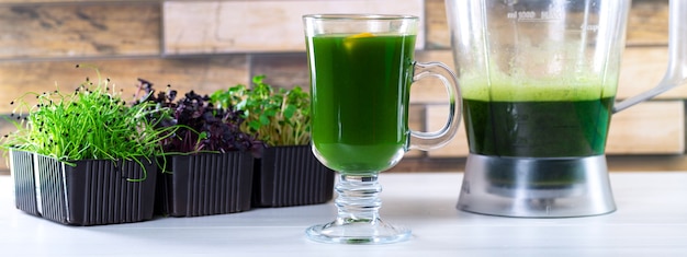 Jus de Microgreen sur la table de la cuisine. Micro verts dans un mélangeur. Préparez un smoothie micro-vert à la maison. Alimentation saine et biologique