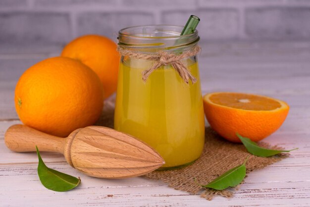 Jus d'orange dans un pot sur une table en bois blanche