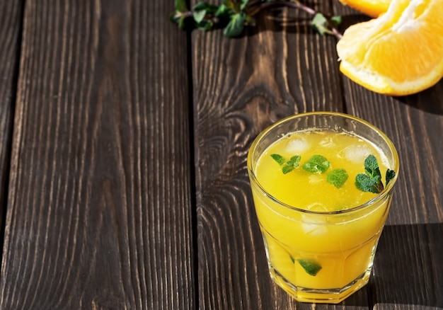 Jus d'orange dans le verre avec des feuilles de menthe