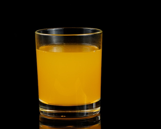 Jus d'orange dans un verre isolé sur noir