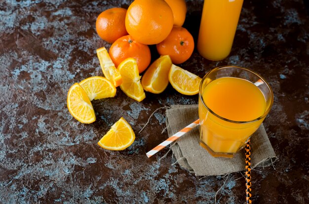 Photo jus d'orange dans un verre et en morceaux