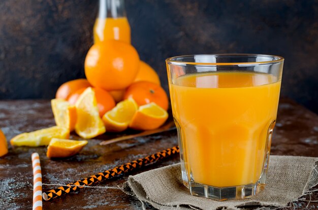 Jus d&#39;orange dans un verre et en morceaux