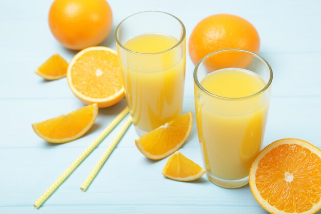 Jus d'orange dans un verre d'oranges et de tranches d'orange sur la table