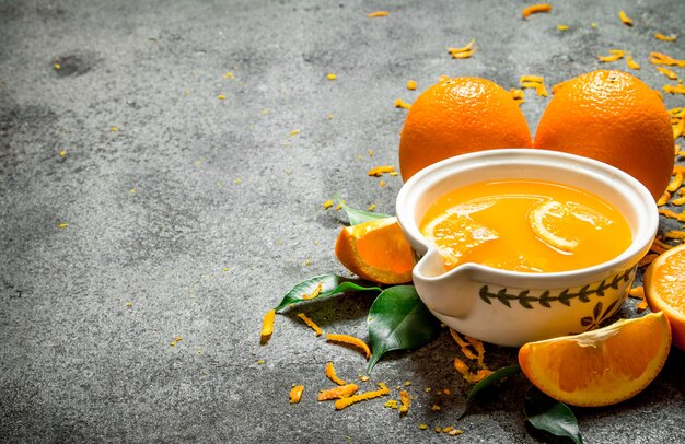 Jus d'orange fraîchement pressé avec des morceaux de fruits sur fond rustique