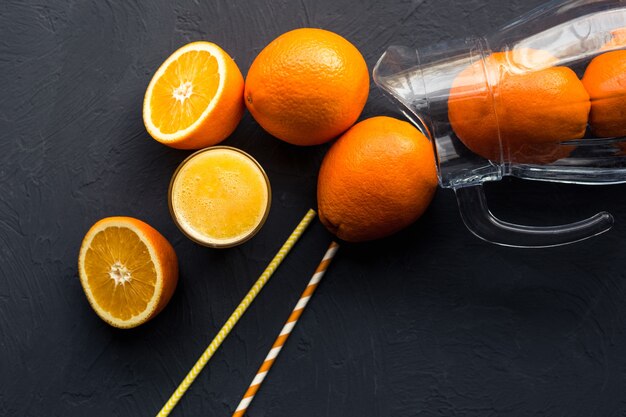 Jus d'orange frais et oranges de fruits frais sur un tableau noir