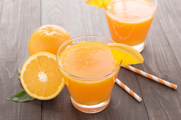 Jus d'orange frais et oranges sur table en bois