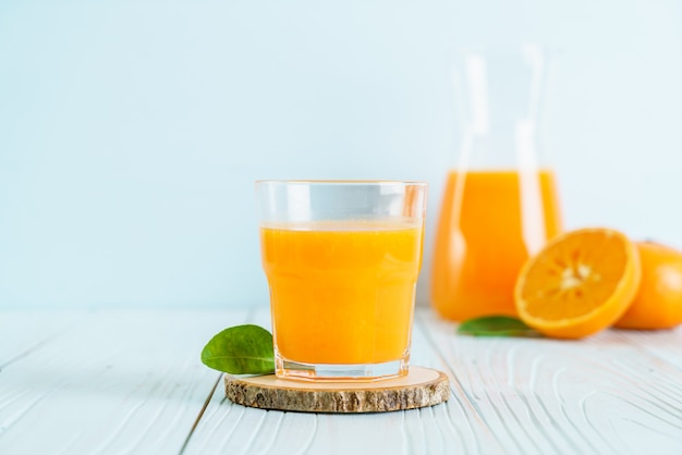 Jus d'orange frais sur la surface du bois