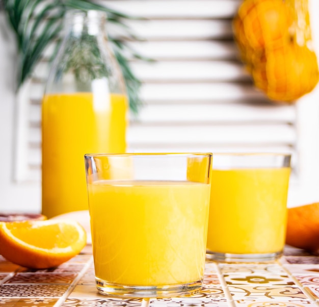 Jus d'orange frais sur table avec tranches de fruits