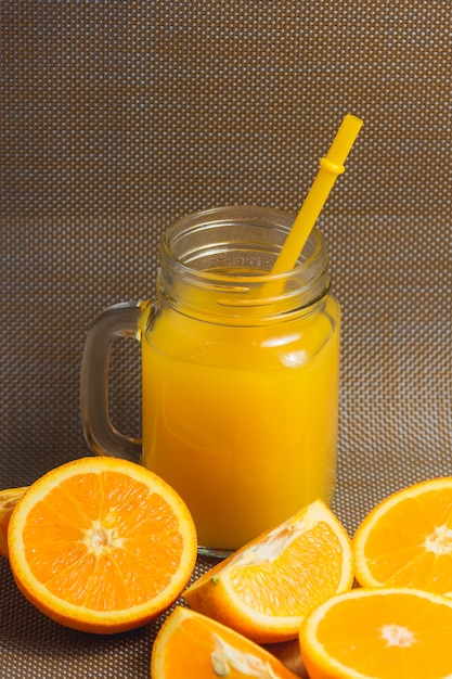 Jus d'orange et jus tranchés sur fond sombre