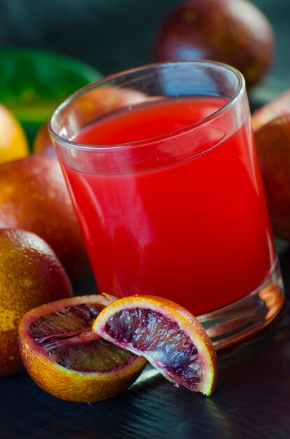 Jus de l'orange sicilienne et fruits frais sur fond noir