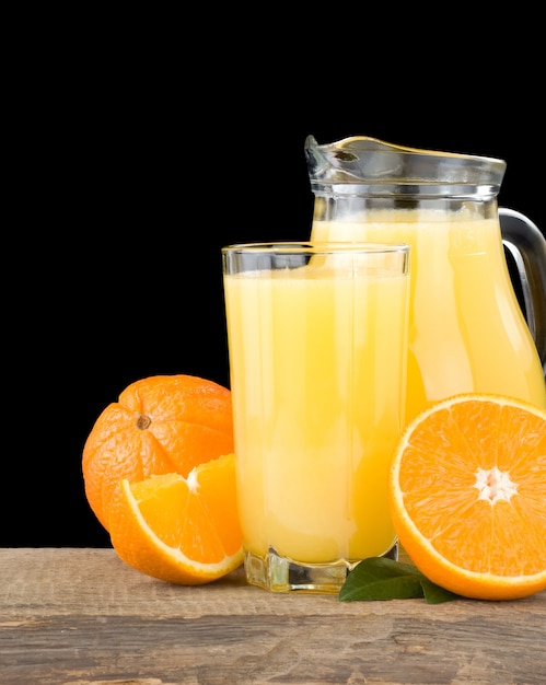 Jus d'orange en verre et tranches isolés sur fond noir