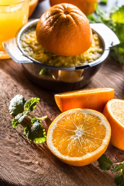 Jus d'oranges fraîches, fruits tropicaux et herbes sur planche de béton.