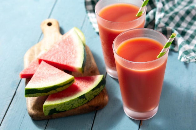 Jus de pastèque frais avec de la glace sur une table en bois bleue