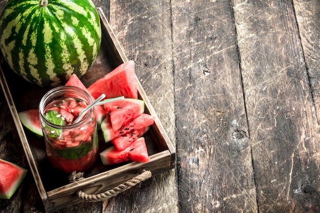 Jus de pastèque frais sur table en bois.