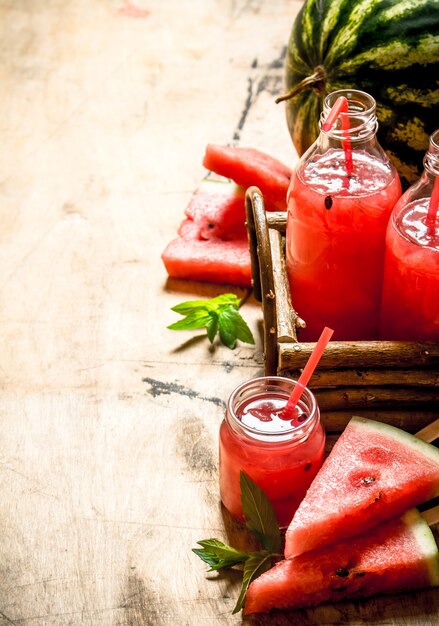 Jus de pastèque avec pulpe sur table en bois.