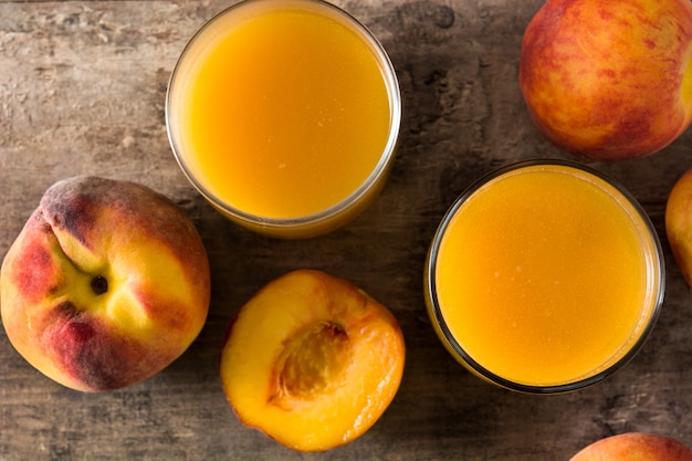 Jus de pêche naturel en verre sur table en bois